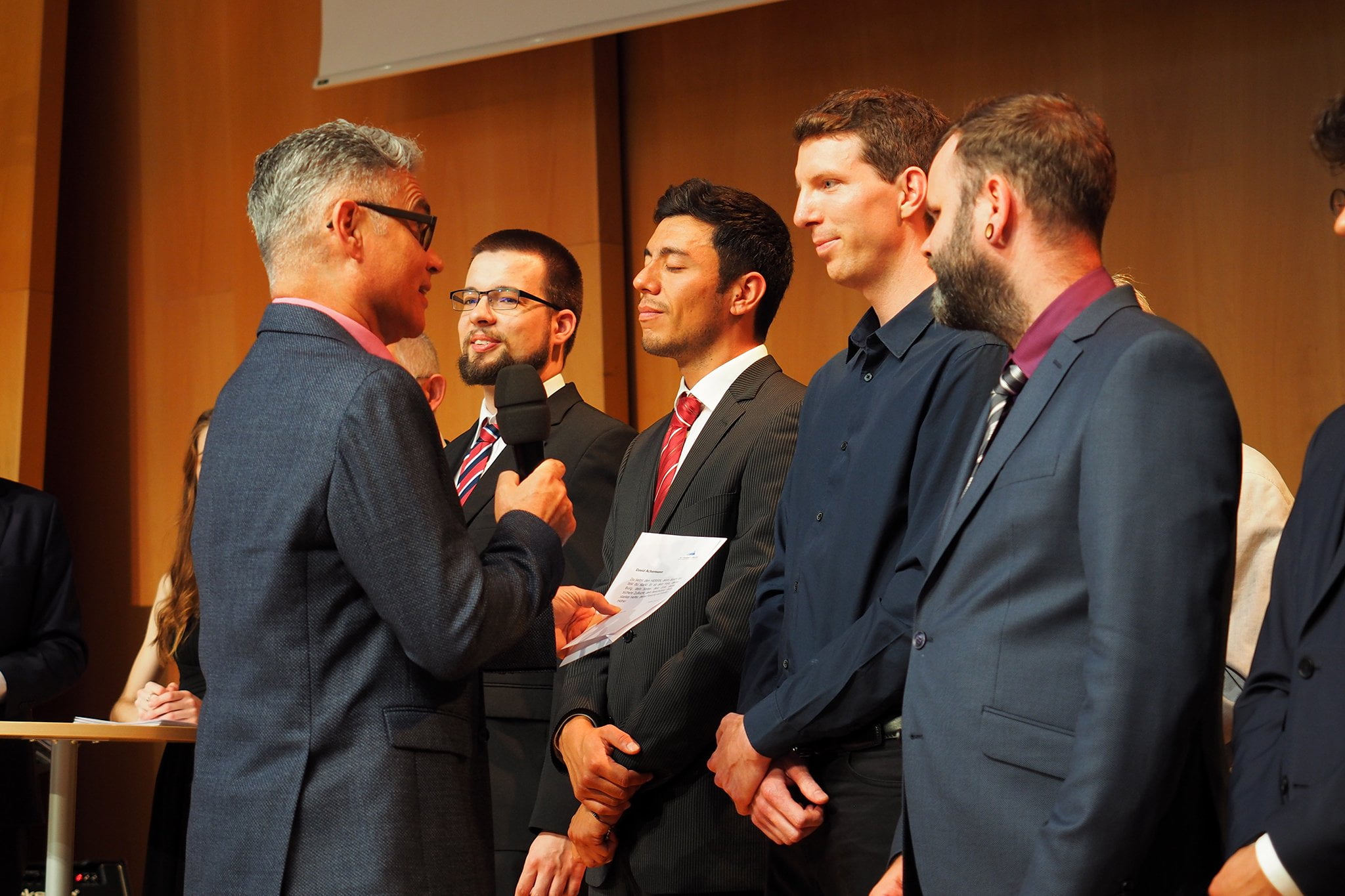 tsc-Jahresfest 2019: Der tsc-Dozent Reiner Bamberger spricht dem tsc-Absolventen David Achermann einen Bibelvers zu.