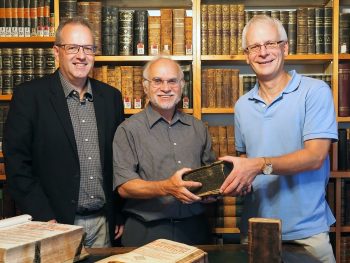 Übergabe der Froschauer-Bibel an die tsc-Bibliothek Martin Gerber (Bildmitte) übergibt die Froschauer-Bibel an Claudius Buser (rechts) im Beisein von Rektor Benedikt Walker.