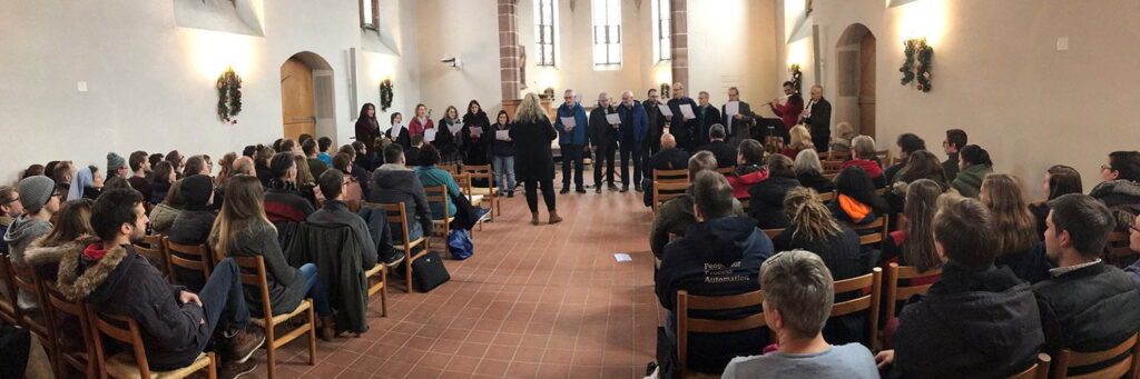 Ein Chor aus Dozierenden und Mitarbeitenden singt der Studiengemeinschaft das Weihnachtslied: «O komm, O komm, du Morgenstern».