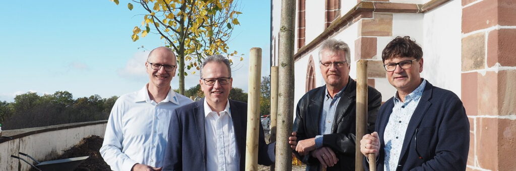 Die Vertreter von CGW (rechts vom Baum) und tsc (links vom Baum) freuen sich über die Pflanzung der CGW-Linde.